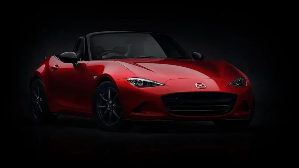 A red Mazda Miata enshrouded in darkness.